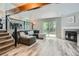 Open living room with wood floors, fireplace, staircase, and sliding glass doors to the backyard at 11481 King St, Westminster, CO 80031