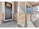 Dark brown front door with a welcoming mat and stone accents at 39 N Waterloo St, Aurora, CO 80018