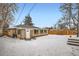 View of backyard with brick home, fence, and a snowy ground at 2280 W Center Ave, Denver, CO 80223