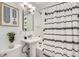 Well-lit bathroom featuring a pedestal sink and shower with modern fixtures at 2280 W Center Ave, Denver, CO 80223