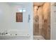 Bright bathroom features soaking tub and walk-in shower with neutral tile at 2280 W Center Ave, Denver, CO 80223