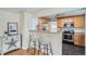 Kitchen with modern appliances, wood cabinets, and bar seating at 2280 W Center Ave, Denver, CO 80223