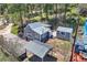 Aerial view of home, outbuilding and carport surrounded by lush greenery at 27389 Highway 74, Evergreen, CO 80439