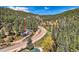 Scenic aerial view of property surrounded by lush greenery and majestic mountains at 27389 Highway 74, Evergreen, CO 80439