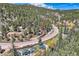 Scenic aerial view of property surrounded by lush greenery and majestic mountains at 27389 Highway 74, Evergreen, CO 80439