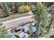 Stunning aerial view of a charming home nestled in a serene wooded location and nearby stream at 27389 Highway 74, Evergreen, CO 80439
