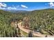 Scenic aerial view of property surrounded by lush greenery and majestic mountains at 27389 Highway 74, Evergreen, CO 80439
