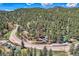 Scenic aerial view of property surrounded by lush greenery and majestic mountains at 27389 Highway 74, Evergreen, CO 80439