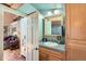 Cozy bathroom with wooden cabinetry, a granite countertop sink, and a view into the living area at 27389 Highway 74, Evergreen, CO 80439