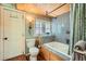 Cozy bathroom with a jacuzzi tub, gray tiled walls, wood ceiling, and a small window for natural light at 27389 Highway 74, Evergreen, CO 80439
