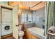 Charming bathroom with wood-paneled ceiling, jacuzzi tub, in-unit washer/dryer for convenience, and natural light at 27389 Highway 74, Evergreen, CO 80439