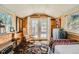 Bedroom featuring wood walls, a single bed, an outdoor view through French doors, and cozy decor at 27389 Highway 74, Evergreen, CO 80439