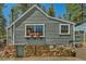 Charming home exterior features gray wood siding with stone foundation and flower box decor at 27389 Highway 74, Evergreen, CO 80439