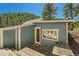 Side exterior view of outbuilding showing door, window, and small patio area at 27389 Highway 74, Evergreen, CO 80439