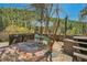 A serene outdoor patio features a glass table, umbrella, and beautiful natural surroundings at 27389 Highway 74, Evergreen, CO 80439