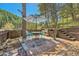 Inviting outdoor patio area with a table, chairs, umbrella, and wooden terraced landscaping at 27389 Highway 74, Evergreen, CO 80439