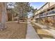 A neighborhood street view with a pathway leading to residential units, surrounded by trees at 3423 Madison Ave # X133, Boulder, CO 80303