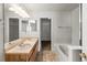 Well-lit bathroom featuring dual sinks, a soaking tub and tiled flooring at 619 S Norfolk Way, Aurora, CO 80017