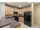 Bright kitchen featuring wood cabinets, black appliances, and neutral countertops at 619 S Norfolk Way, Aurora, CO 80017