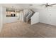 Open-concept living area features neutral paint, carpet, and access to the staircase at 619 S Norfolk Way, Aurora, CO 80017