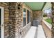 Covered porch featuring stone columns, an AC unit and windows at 619 S Norfolk Way, Aurora, CO 80017