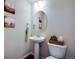 Powder room with pedestal sink, oval mirror, and decorative accents at 16022 W 63Rd Ln # A, Arvada, CO 80403