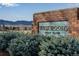 An outdoor sign for 'West Woods Golf Club' set in front of landscaped greenery and mountain views at 16022 W 63Rd Ln # A, Arvada, CO 80403