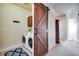 Bright laundry area showcasing a sliding barn door, washer, dryer, and convenient cabinet storage space at 16022 W 63Rd Ln # A, Arvada, CO 80403