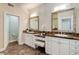 Luxurious bathroom with double vanity, white cabinetry and marble countertops at 2500 E Cherry Creek South Dr # 306, Denver, CO 80209