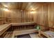 A wood paneled sauna with two levels of wood benches, wood flooring, and wall lighting at 2500 E Cherry Creek South Dr # 306, Denver, CO 80209