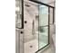 Luxurious shower with glass doors, a built-in bench, modern fixtures, and a marble tile surround at 7873 Sweet Water Rd, Lone Tree, CO 80124