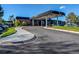View of the brick club entrance featuring a covered awning with circular driveway and landscaping at 2479 S Xanadu Way # C, Aurora, CO 80014