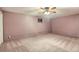 Finished basement room featuring a ceiling fan, neutral carpet and pink painted brick walls at 1720 Chaparro Cir, Berthoud, CO 80513