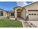 Inviting front entrance with a beautiful wooden door, complemented by well-maintained landscaping and an arched entry at 1720 Chaparro Cir, Berthoud, CO 80513