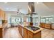 Open kitchen features a gas cooktop island, tile floors, stainless vent hood and plenty of cabinet space at 1720 Chaparro Cir, Berthoud, CO 80513