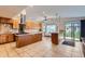Expansive kitchen with tile floors, granite countertops, a center island with cooktop, and bright lighting at 1720 Chaparro Cir, Berthoud, CO 80513