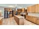 Spacious kitchen with stainless steel appliances, center island, custom cabinets, and tile flooring throughout at 1720 Chaparro Cir, Berthoud, CO 80513