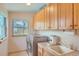 Laundry room with washer, dryer, sink, cabinets, and a window with backyard views at 1720 Chaparro Cir, Berthoud, CO 80513