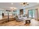 Open-concept living room with hardwood floors, fireplace, and adjacent dining room and access to the backyard at 1720 Chaparro Cir, Berthoud, CO 80513