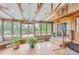 Enclosed sunroom featuring exposed wood beams, brick floor, and many windows with views of the outdoors at 1720 Chaparro Cir, Berthoud, CO 80513