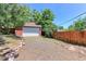 Detached two-car garage with a white door, gravel driveway, and a wooden privacy fence at 760 S 42Nd St, Boulder, CO 80305