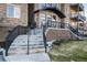 Apartment building entrance with stone accents, an arched awning, and stair access at 6000 W Floyd Ave # 307, Denver, CO 80227