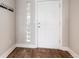 Apartment entryway with wood-look floors, a glass block window, and a coat rack at 6000 W Floyd Ave # 307, Denver, CO 80227
