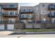 Exterior shot of condo with balconies, brick facade, and lower garages at 6000 W Floyd Ave # 307, Denver, CO 80227