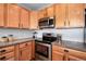 Close-up view of a kitchen featuring stainless steel appliances and wood cabinetry at 6000 W Floyd Ave # 307, Denver, CO 80227