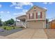 Charming home featuring a covered porch, two-car garage, and professionally landscaped front yard at 4592 Malaya St, Denver, CO 80249