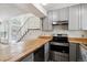 Modern kitchen featuring gray cabinets, hardwood countertops, and stainless steel appliances at 4592 Malaya St, Denver, CO 80249