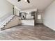 Open-concept living space featuring hardwood floors, staircase, and adjacent kitchen area at 4592 Malaya St, Denver, CO 80249
