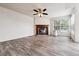 Spacious living room with wood-burning fireplace, ceiling fan, and hardwood flooring at 4592 Malaya St, Denver, CO 80249