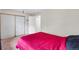 Simple bedroom design featuring a vibrant red bedspread, neutral walls, and sliding closet doors at 1216 S Uvalda St, Aurora, CO 80012